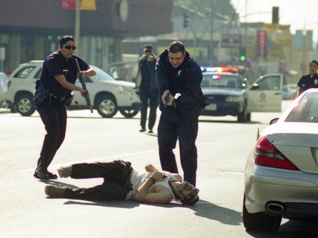 Los Angeles Police officers advancing on a wounded gunman 