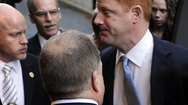 Penn State assistant football coach Mike McQueary, right, arrives at Dauphin County Court surrounded by heavy security Friday, Dec 16, 2011, in Harrisburg, Pa. 