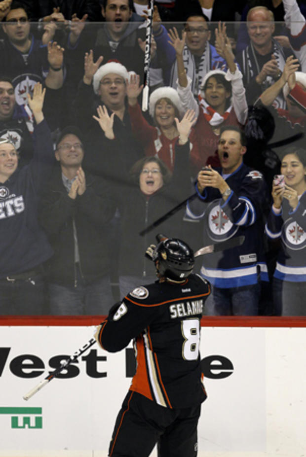 Teemu Selanne tosses his stick into the crowd  