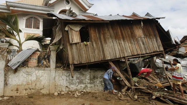 Residents retrieve their household items from flood debris 