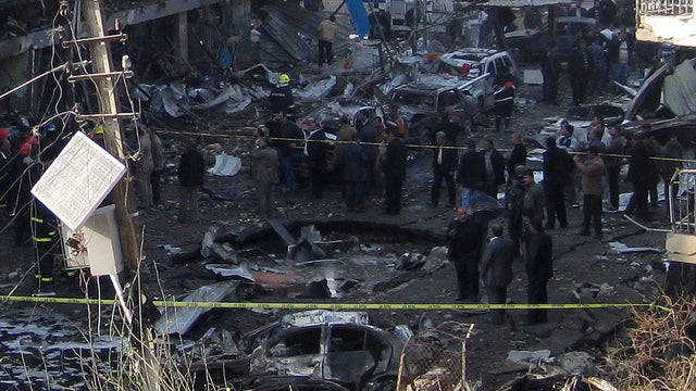 Iraqi security forces inspect a crater caused by a car bomb 