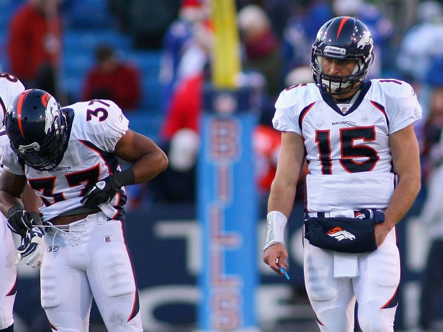 Tim Tebow stands on the field after throwing an interception  