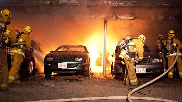 Los Angeles Fire Department firefighters extinguish numerous cars on fire in a carport in the Sherman Oaks neighborhood of Los Angeles on Jan. 2, 2012. 