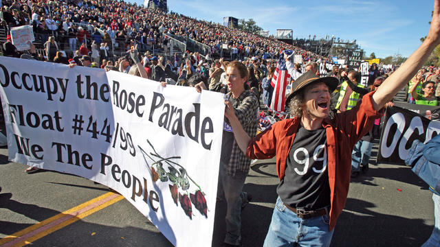 Occupy protesters march along Colorado Boulevard during the 123rd Tournament of Roses Parade in Pasadena, Calif., Monday, Jan. 2, 2012. Several thousand Occupy protesters marched at the end of the Rose Parade in a pre-arranged demonstration.  