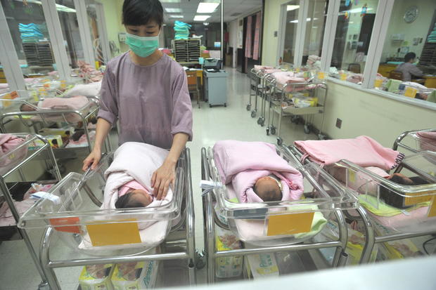A nurse inspects a newborn baby at a nur 