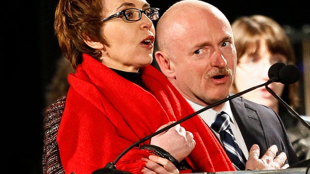 Rep. Gabrielle Giffords leads the Pledge of Allegiance accompanied by her husband, former astronaut Mark Kelly, Jan. 8, 2012, in Tucson, Ariz., at the start of a memorial vigil remembering the victims and survivors one year after the Arizona congresswoman 