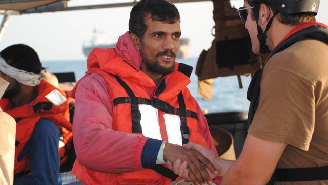 An Iranian mariner greets a U.S. Coast Guardsmen assigned to the U.S. Coast Guard Cutter Monomoy (WPB-1326). Monomoy rendered assistance to six Iranian mariners who had to abandon their dhow, Ya-Hussayn, after its engine room flooded. Monomoy is assigned  