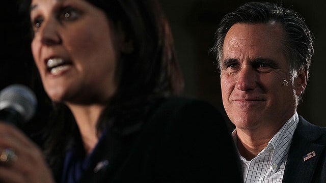 Republican presidential candidate and former Massachusetts governor Mitt Romney looks on as South Carolina Gov. Nikki Haley speaks during a spaghetti dinner at Tilton School on January 6, 2012 in Tilton, New Hampshire.  