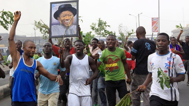 A angry youth protests in front of a burning barrier following the removal of a fuel subsidy by the government in Lagos, Nigeria, Jan. 10, 2012. Angry youths erected a burning roadblock outside luxury enclaves in Nigeria's commercial capital as a paralyzi 