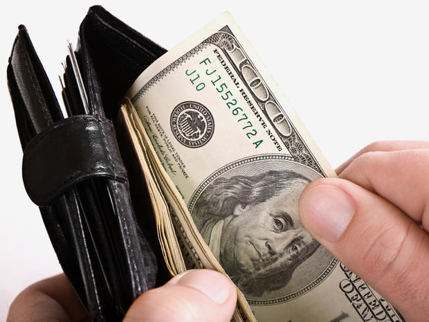 Man holding a wallet with cash in it. 