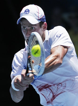 Novak Djokovic makes a backhand return 