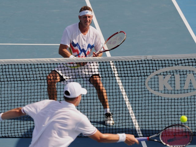 John Isner makes a forehand return to David Nalbandian 