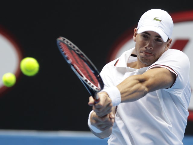 John Isner of the US hits a backhand return 