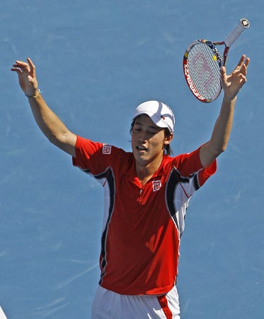 Japan's Kei Nishikori raises his arms in celebration  