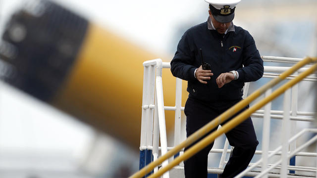 An Italian Navy officer checks the time in the harbor of the Tuscan island of Giglio, Italy, where the cruise ship Costa Concordia ran aground Jan. 23, 2012. 