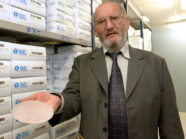 Former PIP President Jean-Claude Mas holds a breast implant 