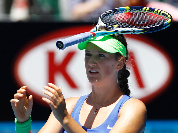 Victoria Azarenka  puts  a racket on her head after she lost a point 