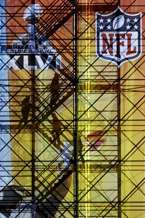 Rider climb up scaffolding for a ride down one of the four 800-foot-long zip lines in the Super Bowl Village 