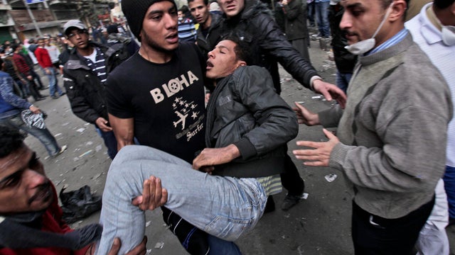 Egyptian protesters carry a wounded man during clashes with security forces near the Interior Ministry in Cairo Feb. 3, 2012. 