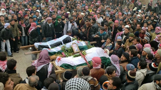 In this undated citizen journalism image provided by the Local Coordination Committees in Syria and accessed on Wednesday, Feb. 8, 2012, mourners gather around the bodies of people allegedly killed by Syrian government forces, during a funeral procession  