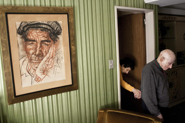 Marcos leads Monica from their room to the living room in Buenos Aires. Monica was diagnosed with Alzheimer's disease. 
