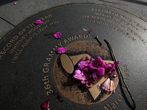 Flowers placed on a Grammy sidewalk plaque honoring Whitney Houston's wins for Record of the Year and Album of the Year 