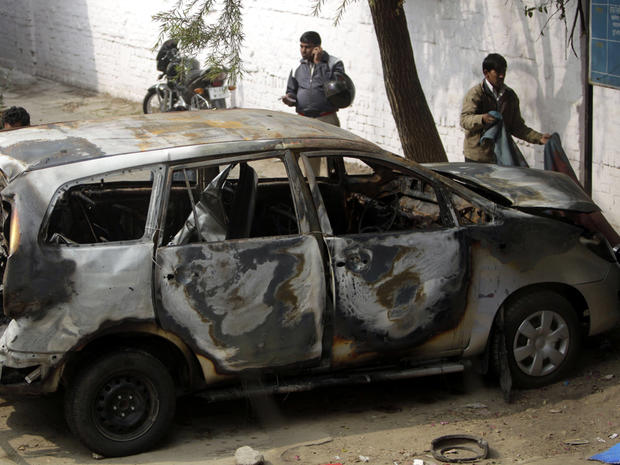 Police officers stand around an Israeli diplomat's car that was damaged in an explosion in New Delhi, India, Feb. 14, 2012. Indian investigators were searching for the motorcycle assailant who attached a bomb to an Israeli diplomatic car in the heart of New Delhi in an attack the Jewish state blamed on Iran or its proxies. 