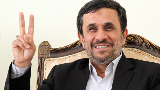 Iranian President Mahmoud Ahmadinejad flashes the V-sign for victory as he waits for the arrival of Ismail Haniya, Palestinian Hamas premier in the Gaza Strip, for a meeting in Tehran, Iran, Feb. 12, 2012. 