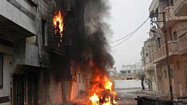 In this Feb. 15, 2012 citizen journalism image provided by the Local Coordination Committees in Syria and accessed on Thursday, Feb. 16, 2012, flames leap the air from a car and building bombed by the Syrian government forces shelling, in Baba Amr neighbo 