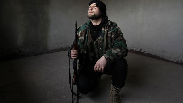 Syrian rebel looks out after Syrian army tanks enter the northwestern city of Idlib 