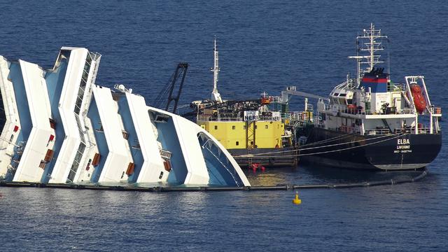Ongoing operations to remove fuel from the half sunken hulk of the luxury ship Costa Concordia a month after it ran aground are seen outside the port of Isola del Giglio island in Tuscany, Italy, Feb. 13, 2012. 