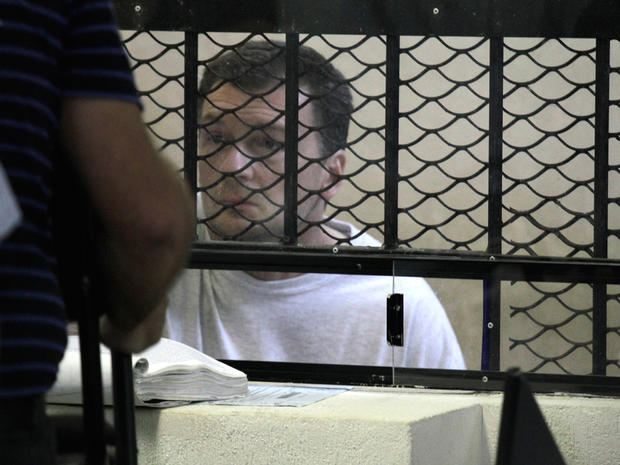 Reality television producer Bruce Beresford-Redman attends a court hearing from behind a fenced window at the prison in Cancun, Mexico 