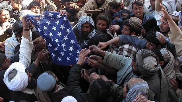 Afghan demonstrators destroy a U.S. flag 