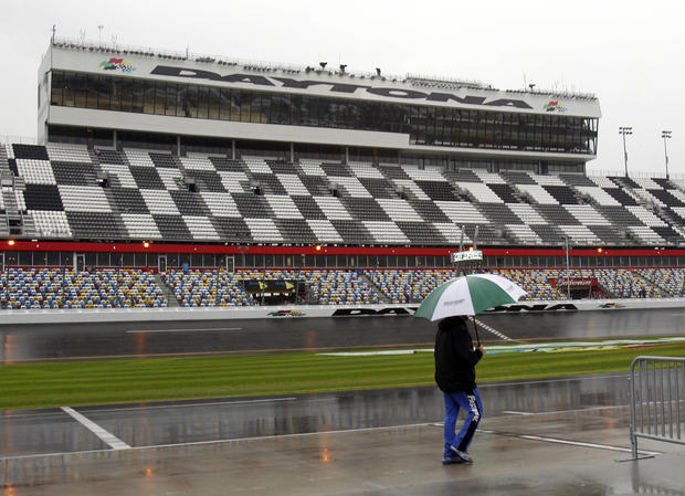 crew member walks down pit road as officials hope to start the rain-postponed NASCAR Daytona 500 