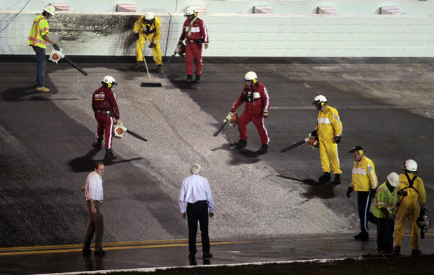 Workers finish repairing an area in the track that was damaged by a fuel leak 