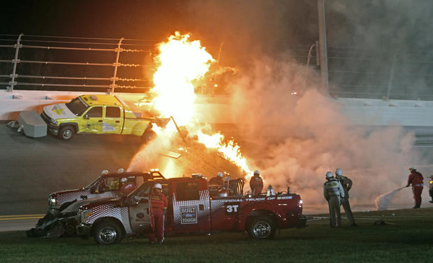Emergency workers try to put out a fire after Juan Pablo Montoya's car struck the truck 
