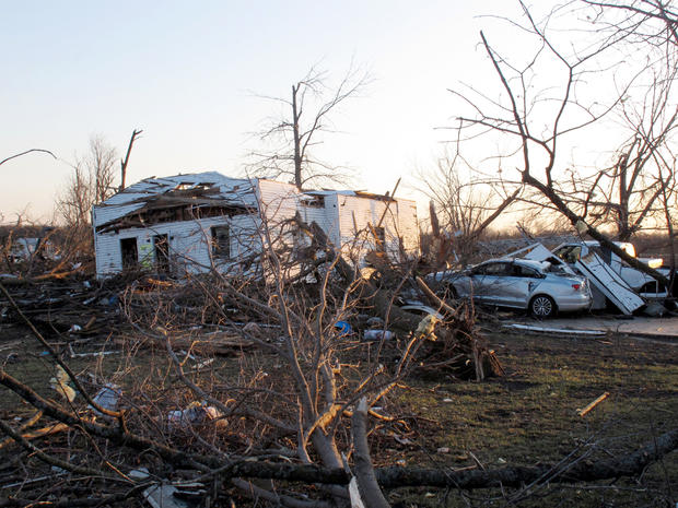 A tornado-damaged home sits amid debris 