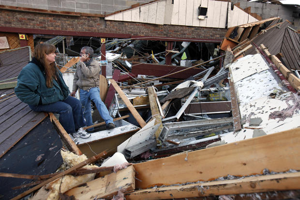 Sherry Cousins and her brother Bruce Wallace of Hollister, Mo., sit in the wreckage of their secondhand store 