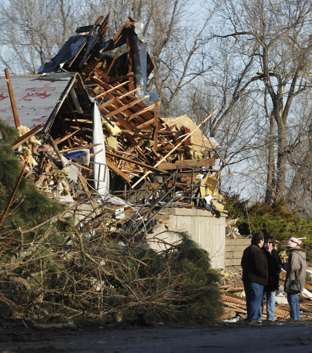 Residents talk in front of a home after severe storms destroyed several homes  