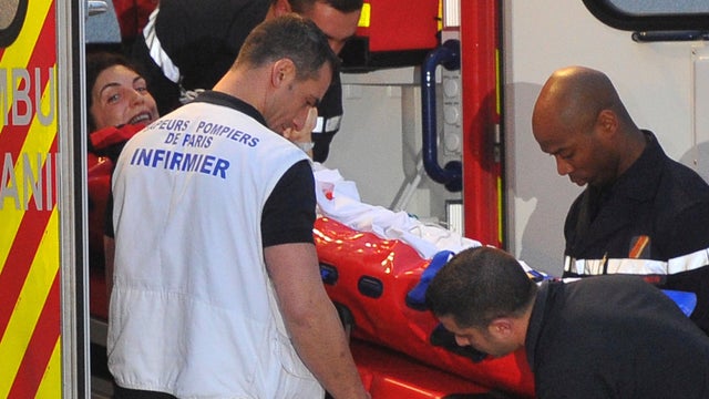 French journalist Edith Bouvier smiles as firefighters carry her into an ambulance after the plane carrying her and French photographer, William Daniels, landed at the Villacoublay military airport outside Paris, Friday, March 2nd, 2012.  
