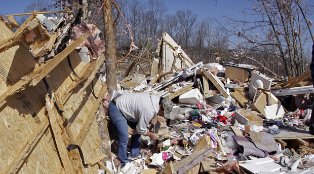 Sheila Skaggs, daughter of Harold and Carolyn Jones, sifts through the remains of her parents home  