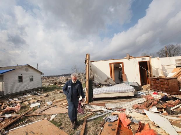 Keith Huke walks past what remains of his tornado-ravaged home 