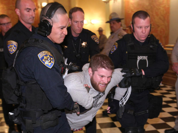 Highway Patrol Officers carry out a protester after he refused to leave the state Capitol in Sacramento 