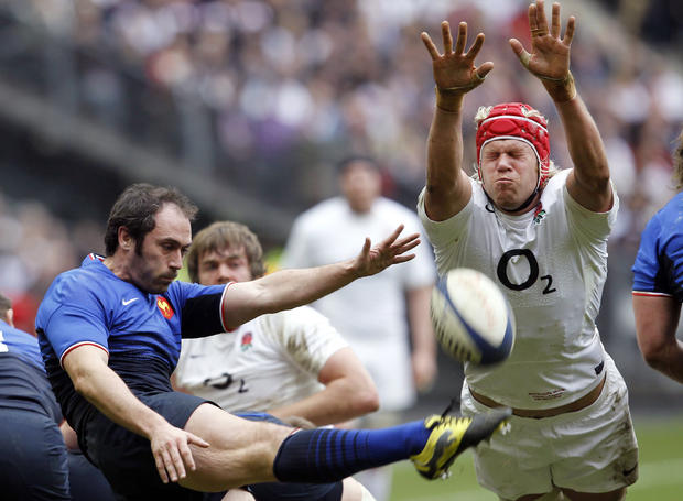 Julien Dupuy, left, kicks the ball, as England's Mouritz Botha tries to stop it 