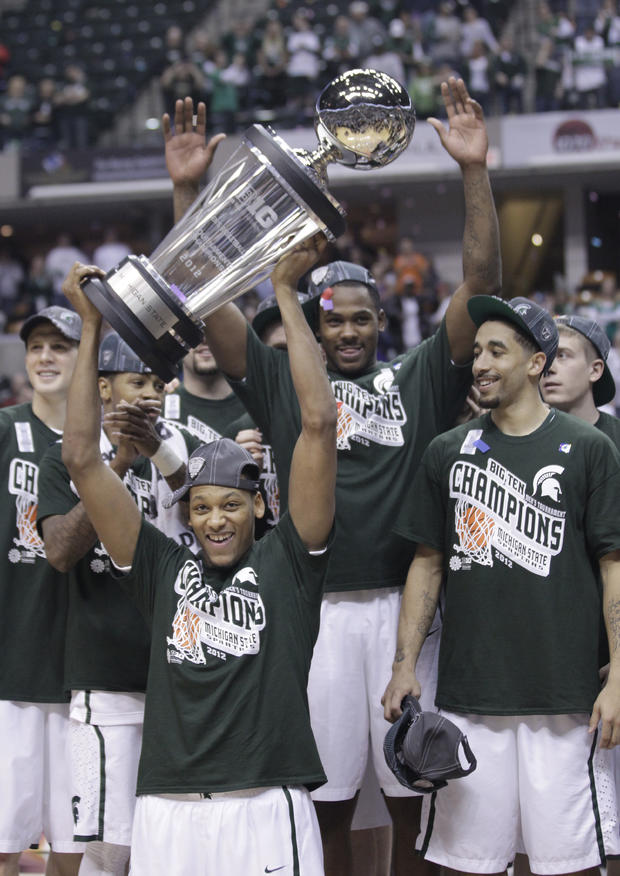 Michigan State center Adreian Payne holds up the Big Ten tournament trophy 