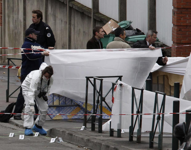 Police officers gather evidence at the site of a shooting in Toulouse 