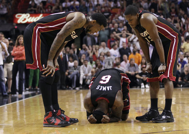 Udonis Haslem, left, and Mario Chalmers, right, check on teammate LeBron James 