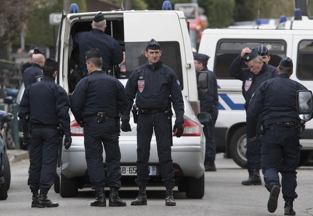 Police officers stand near a building in Toulouse, France, March 21, 2012, where a suspect in the shooting at the Ozar Hatorah Jewish school is barricaded in an apartment building. 