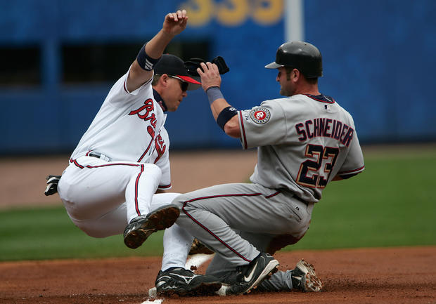 Chipper Jones  tumbles after tagging out Brian Schneider 