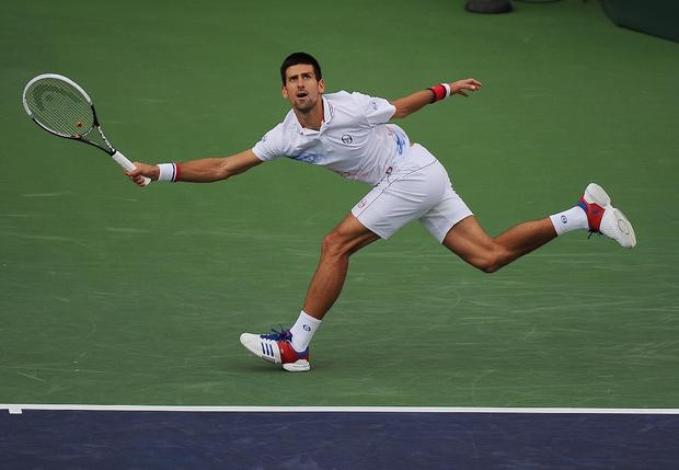 Novak Djokovic returns a shot to John Isner 